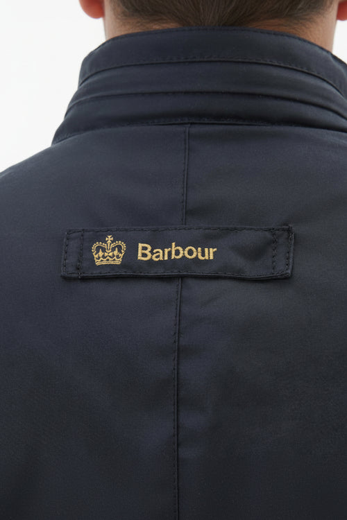 Men's navy wax jacket back yoke with Barbour brand patch near the collar