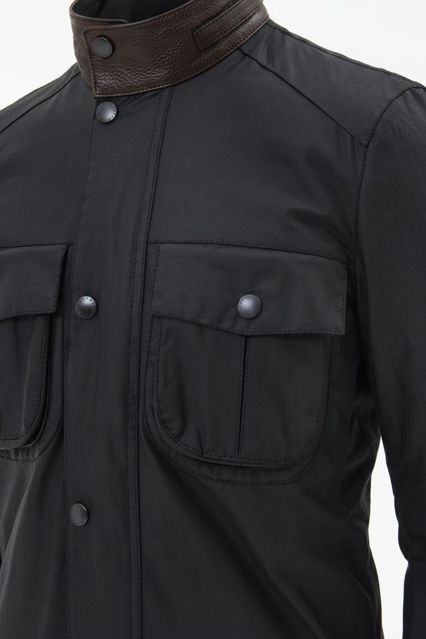 Men's navy wax jacket close-up of buttoned chest pockets and stand collar