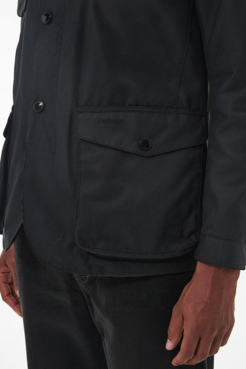 Men's black wax jacket front with flap chest pocket and snap buttons
