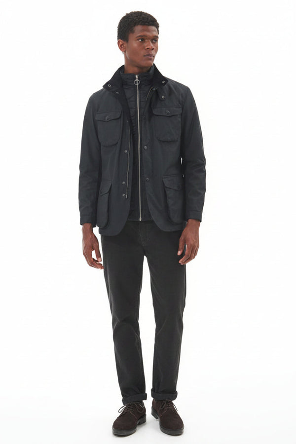 Men's black wax jacket worn over shirt with full button front and flap pockets