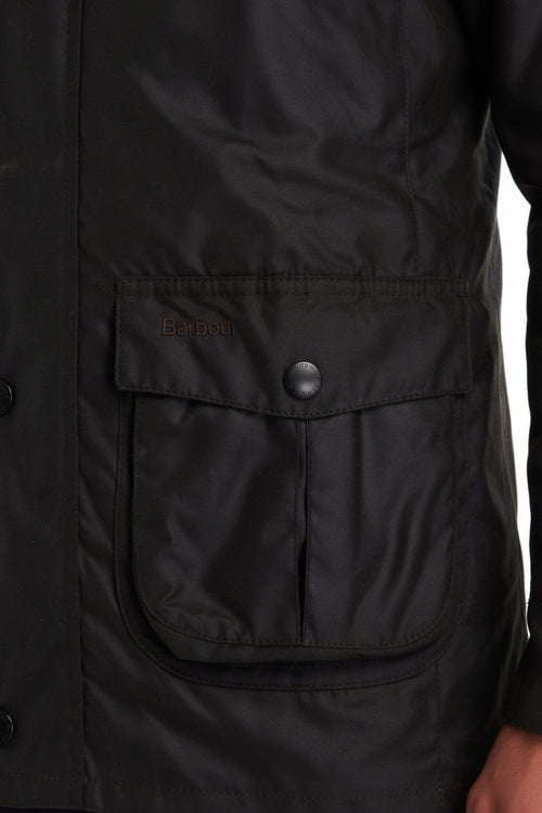 Barbour wax jacket pocket detail with embroidered logo and snap button flap