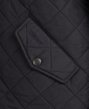 Barbour quilted jacket detail: dark navy diamond quilting and brand patch