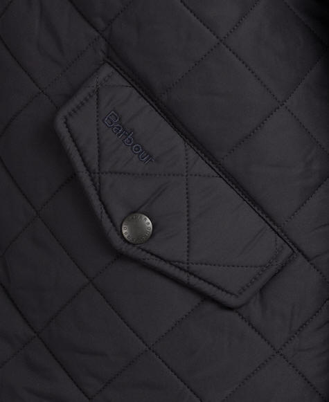 Barbour quilted jacket detail: dark navy diamond quilting and brand patch