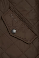 Quilted olive jacket pocket with Barbour logo patch and snap button