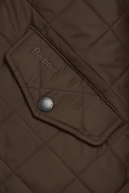 Quilted olive jacket pocket with Barbour logo patch and snap button
