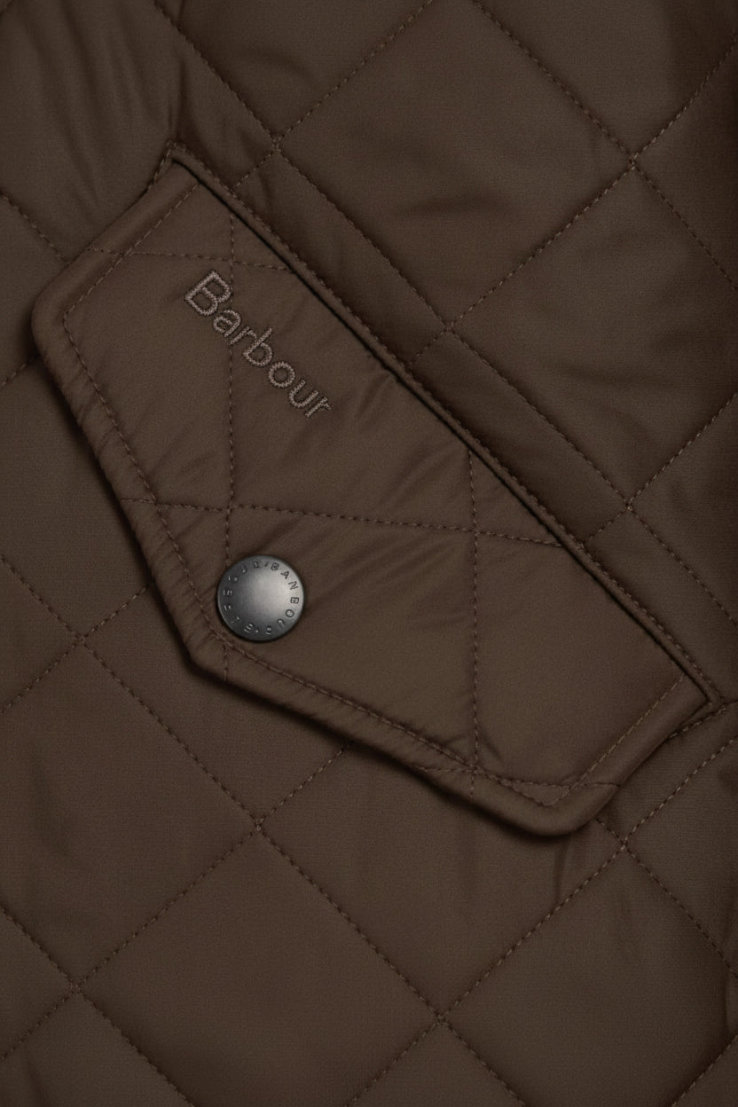 Quilted olive jacket pocket with Barbour logo patch and snap button