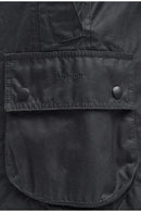 Barbour logo on black wax jacket front pocket with snap buttons