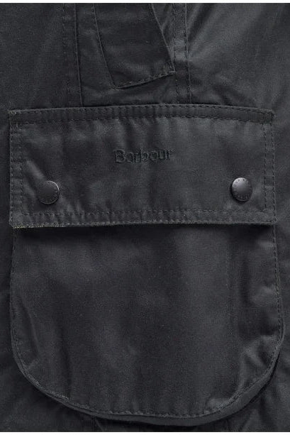 Barbour logo on black wax jacket front pocket with snap buttons