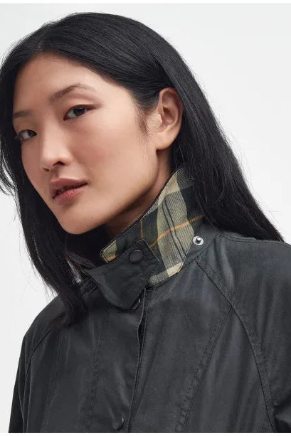 Women's black wax Beadnell jacket with plaid inner collar and snap buttons