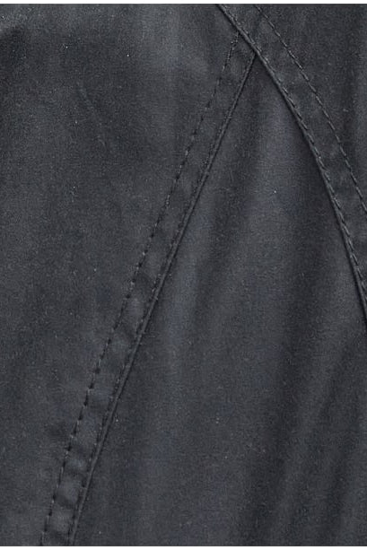 Black wax fabric close-up with stitched seam lines