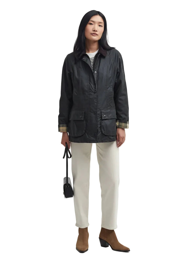 Women's black wax Beadnell jacket with drawstring hem and patch pockets, full length