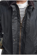 Women's black wax jacket front detail, zipper, snap buttons, toggle badge