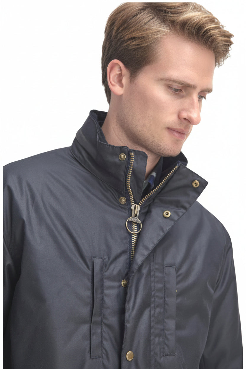 Men's waxed jacket close-up with brass snaps, zip front, and stand collar