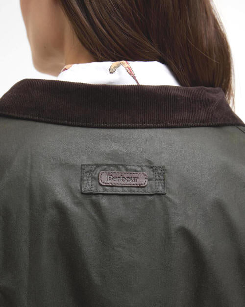 Women's waxed jacket neckline with Barbour patch and dark brown corduroy collar.