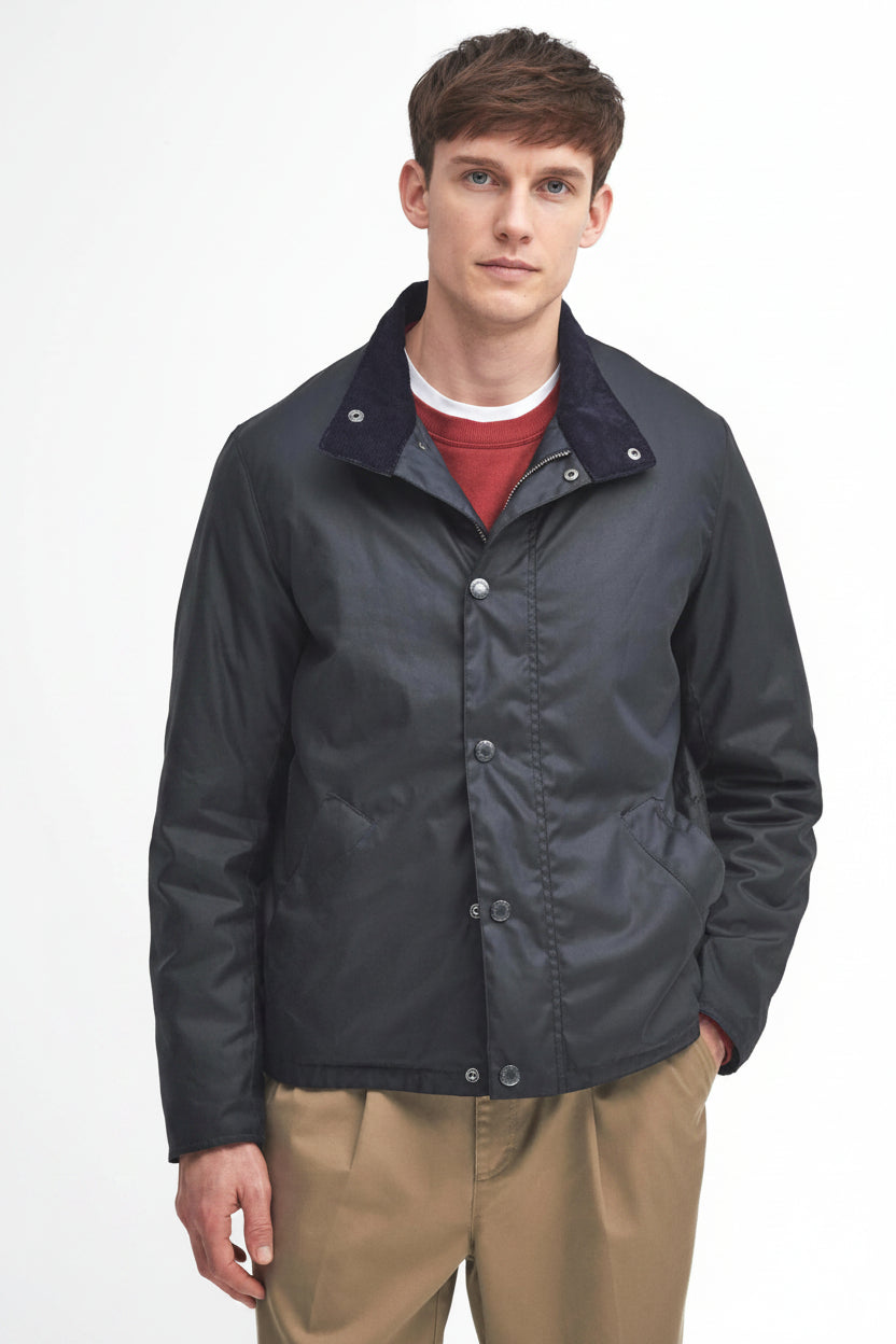 Navy wax jacket with zip front and stand collar, worn with red shirt