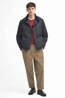 Navy wax jacket with zip front and stand collar, worn over red top