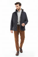 Mens quilted jacket worn over a check shirt with brown trousers