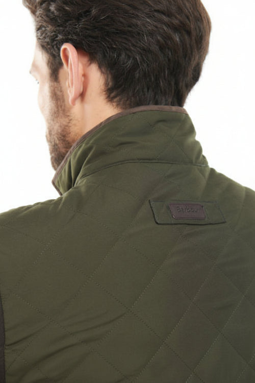 Olive quilted jacket with high collar, back yoke seam, and small logo patch