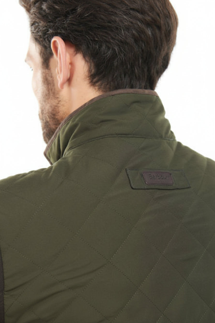 Olive quilted jacket with high collar, back yoke seam, and small logo patch