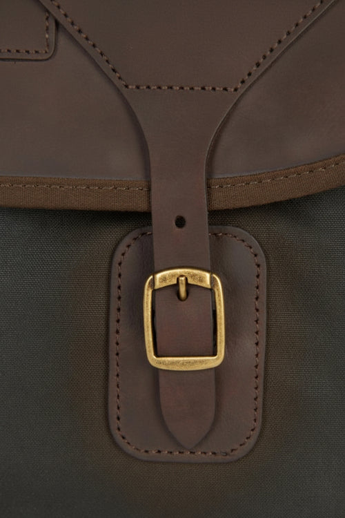 Dark olive leather tab with brass buckle on waxed canvas Tarras bag
