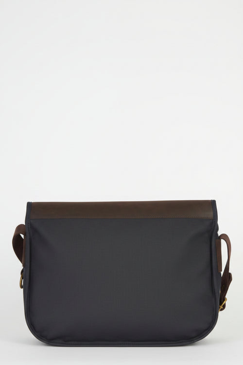 Navy messenger bag with brown leather-trim back and rounded flap edge