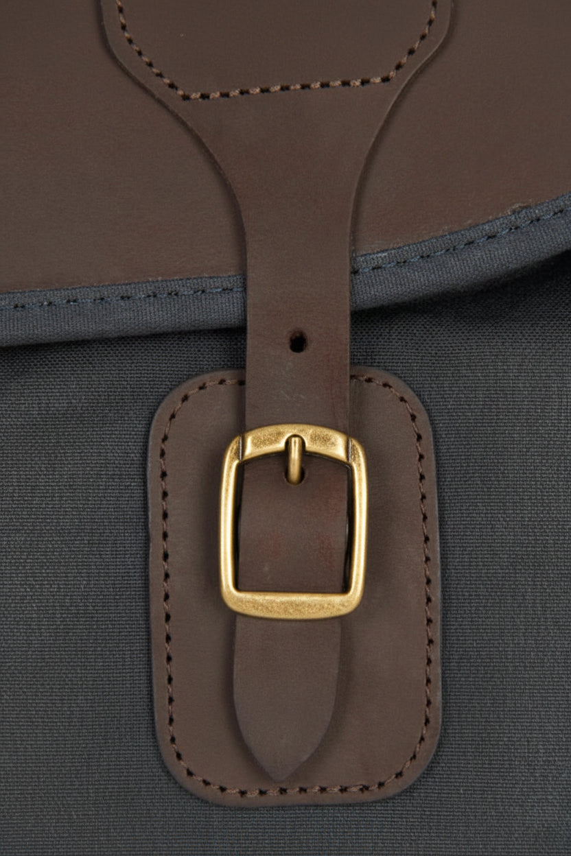 Leather strap keeper with gold-tone buckle on dark navy bag front