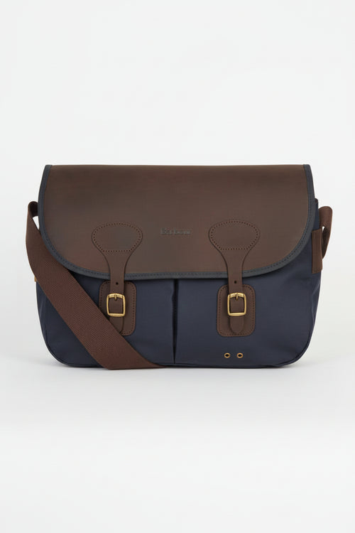 Navy and brown flap messenger bag with leather buckles and front panel seams