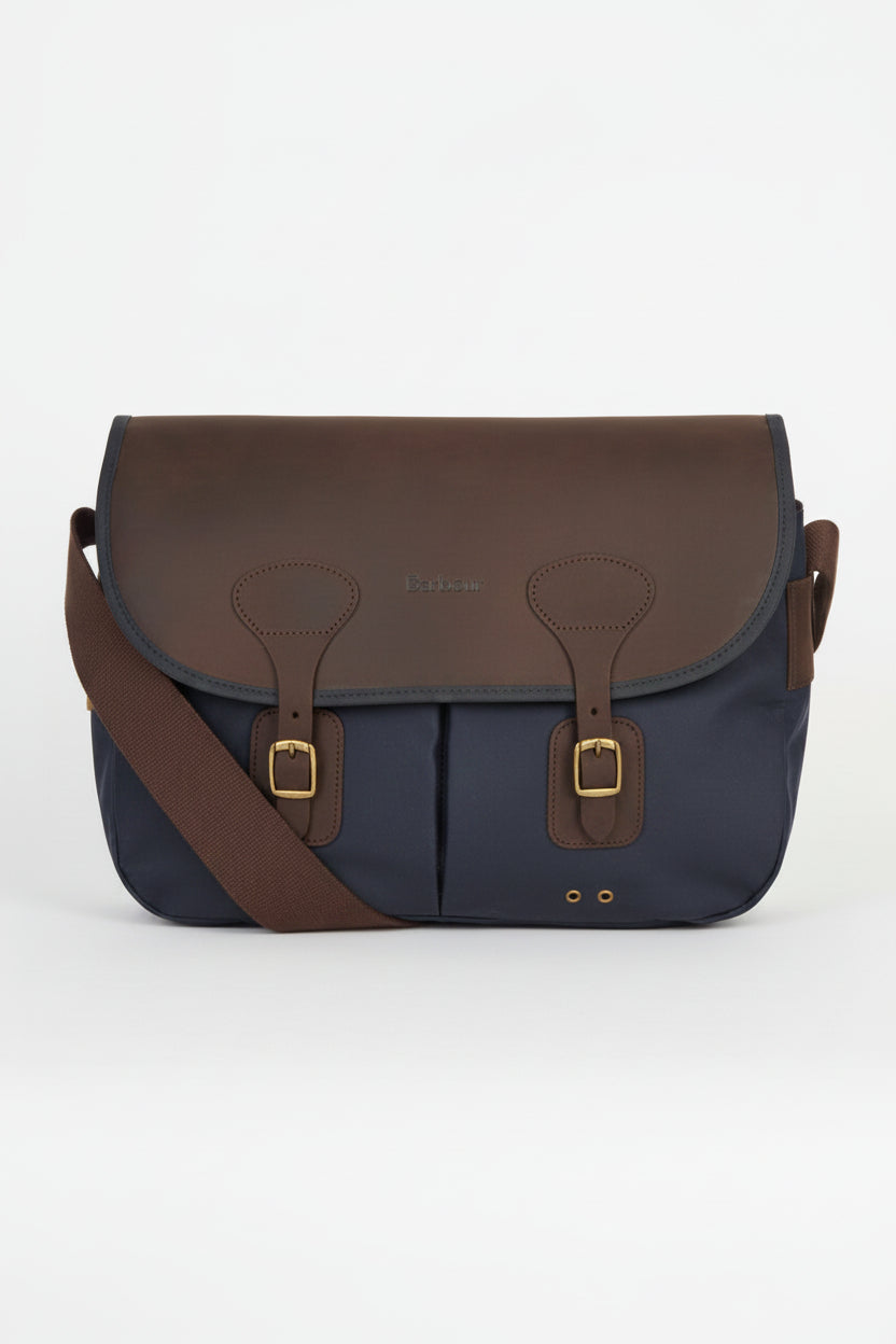 Navy and brown flap messenger bag with leather buckles and front panel seams