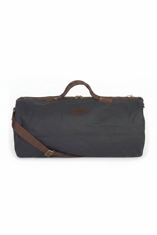 Wax holdall bag in dark navy with leather handles and shoulder strap