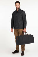 Navy wax holdall bag with leather straps, zip closure, and carry handles