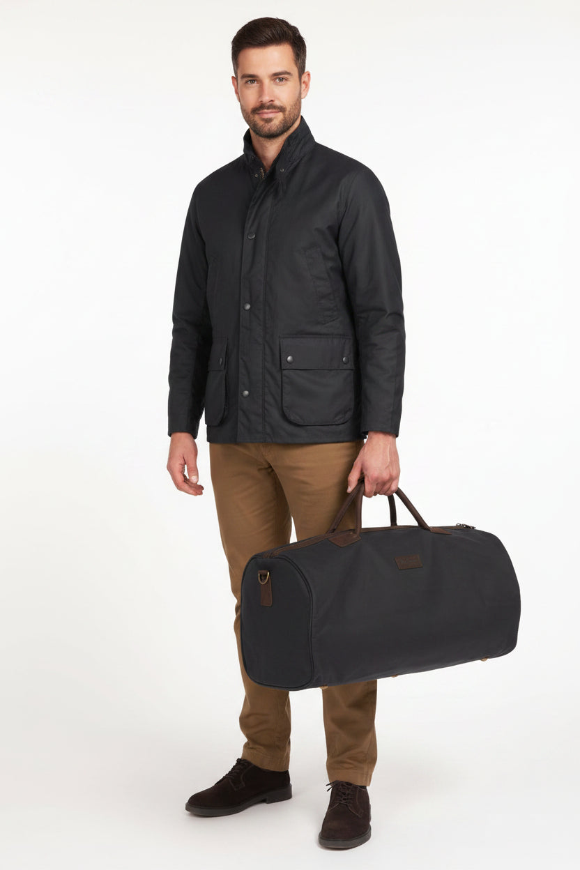 Navy wax holdall bag with leather straps, zip closure, and carry handles