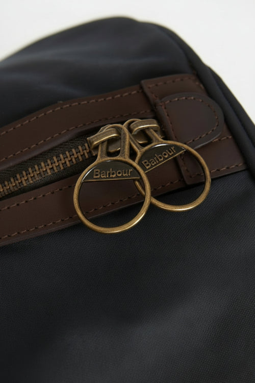 Dark navy holdall bag with brass double-ring zip pulls and leather trim