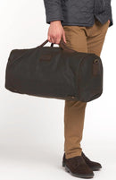 Barbour wax holdall bag held by top handle, olive fabric with leather trim