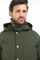 Men's sage green winter jacket neckline close-up with hood, snap buttons, and chin coverage.