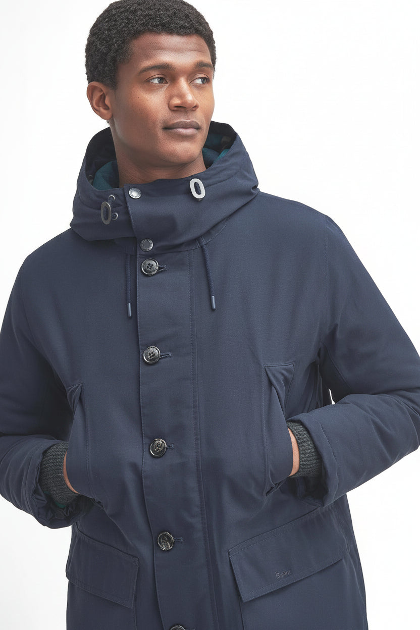 Navy waterproof parka with hood, pockets, and snap-button front detail.