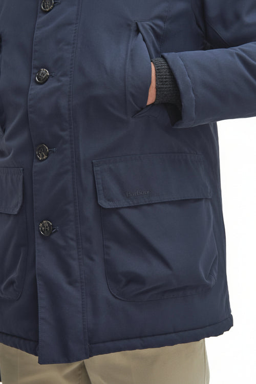 Navy parka with sleeve cuff and front pocket, snap placket, Barbour logo tab.