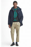 Navy waterproof parka with hood and zip, worn over a green argyle knit.