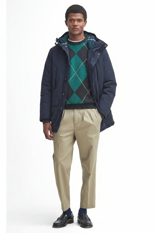 Navy waterproof parka with hood and zip, worn over a green argyle knit.