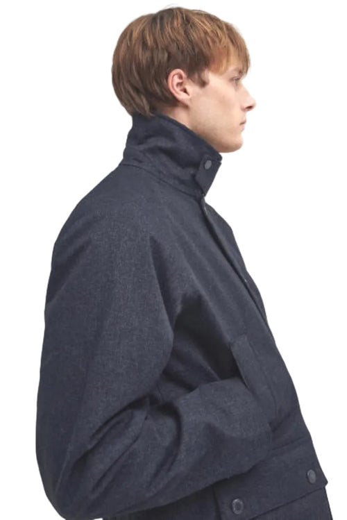 Navy waterproof Bedale jacket side view, stand collar, buttoned storm flap