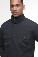 Dark jacket with high neck, snap-flap chest pockets, and button front
