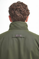 Olive waterproof jacket with high stand collar and Barbour logo patch at back neck