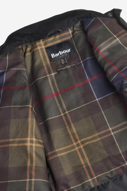 Plaid tartan lining inside black wax jacket with Barbour tag near chest