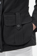 Black wax jacket front pocket flap with snap and stitched panel detail