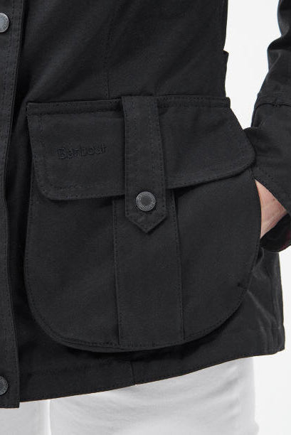 Black wax jacket front pocket flap with snap and stitched panel detail
