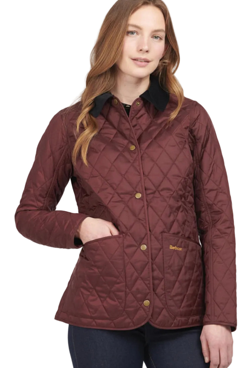 Women’s quilted jacket with black collar, gold buttons, and Barbour logo at hem
