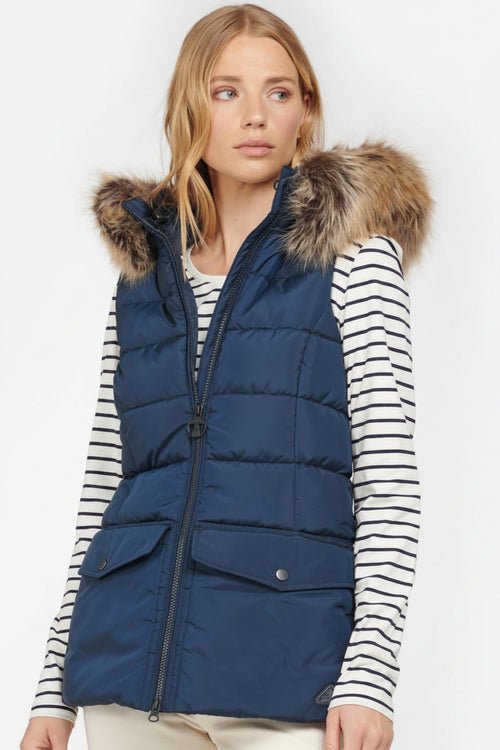 Navy quilted gilet with faux fur hood trim, zip front, and flap pockets