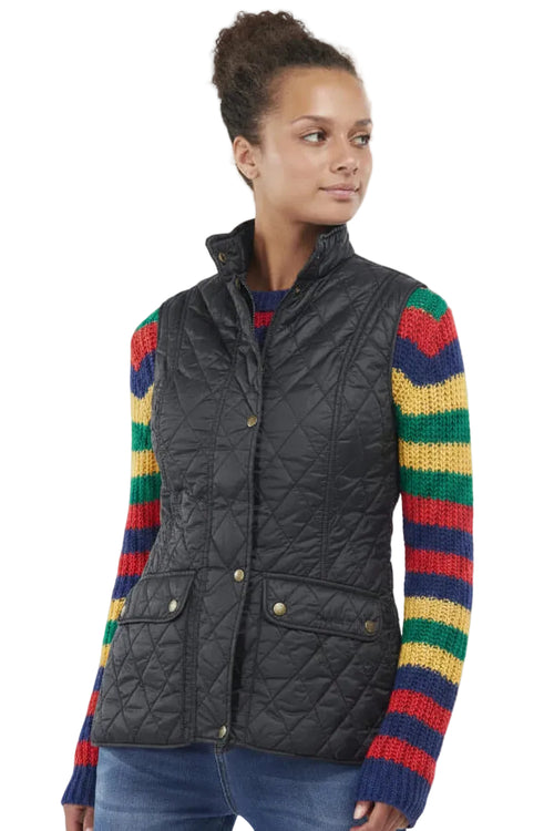 Black quilted gilet worn with colorful striped sleeves, button front and pockets