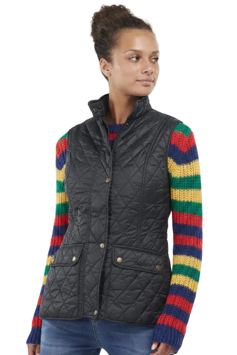 Black quilted gilet worn with colorful striped sleeves, button front and pockets