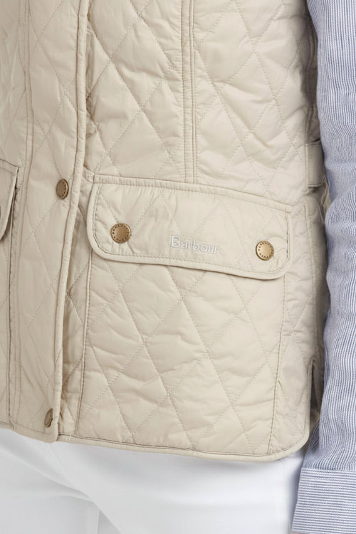 Women's quilted gilet pocket detail with snap buttons and Barbour logo tab.