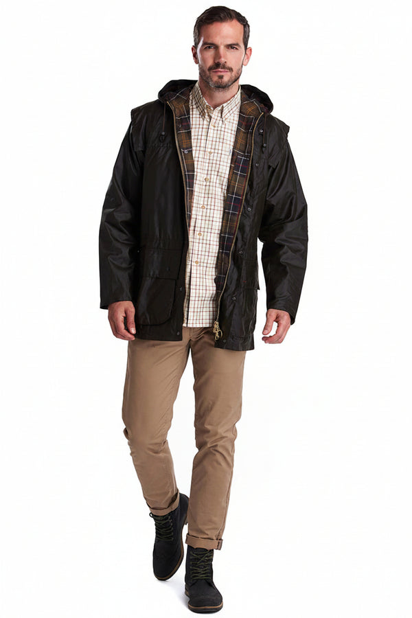 Men's hooded wax jacket with full zip, worn with tan trousers, dark.